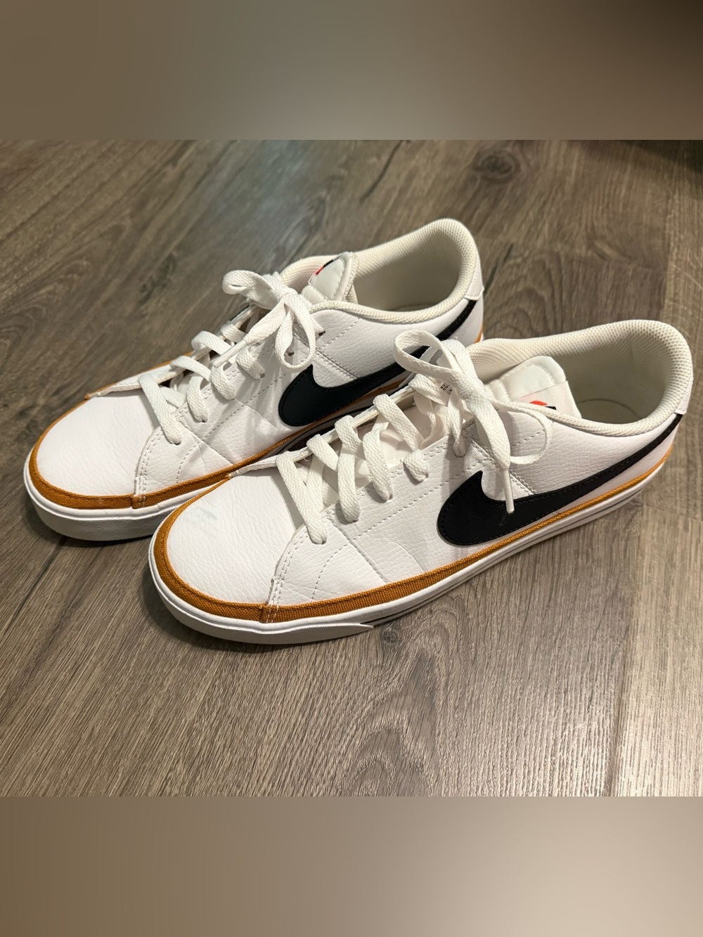 Nike White Low-Top Sneakers with Black Swoosh and Orange Accent